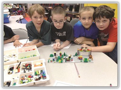 Montour students work together with LEGOs in Burkett Elementary School’s new STEAM room to construct a narrative, which they also write on computers, thereby creating a cross-discipline exercise. Photo submitted.   LEGO3